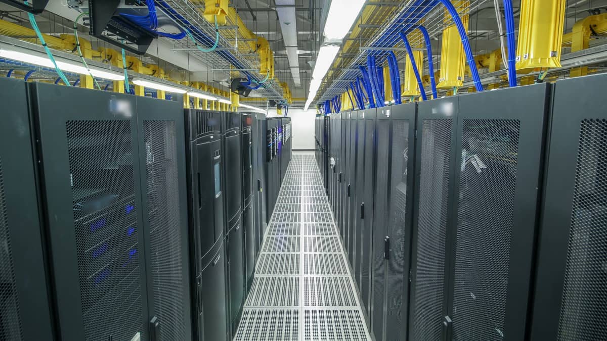 Filas de bastidores de servidores en el pasillo de un centro de datos