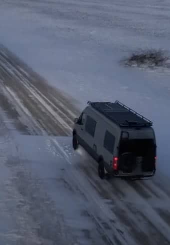 Furgoneta médica estacionada en una carretera rural cubierta de nieve