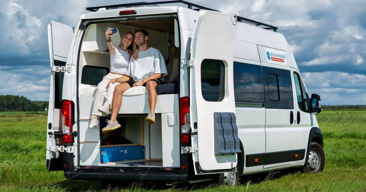 Pareja relajándose frente a su autocaravana