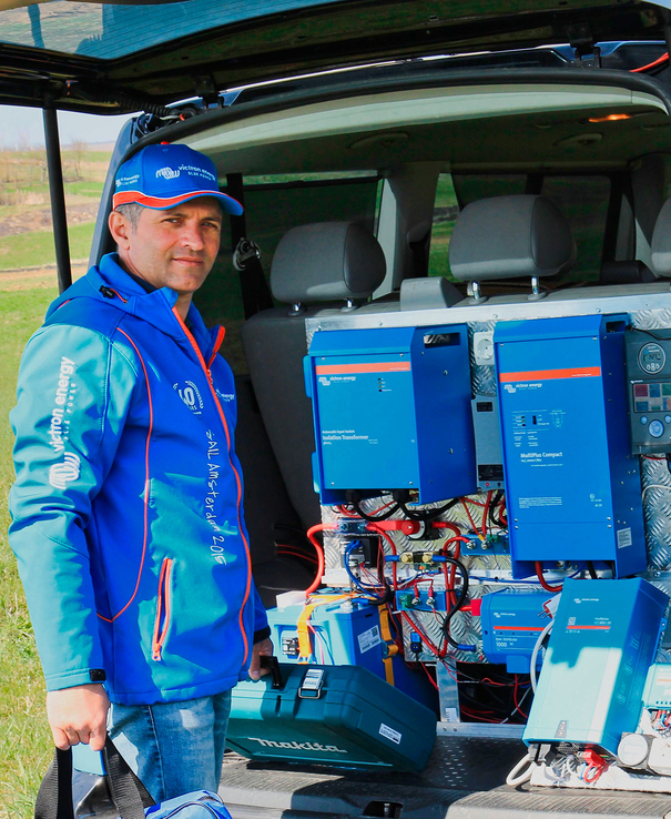 Un representante de Victron Professionals al lado de un coche con equipo de Victron