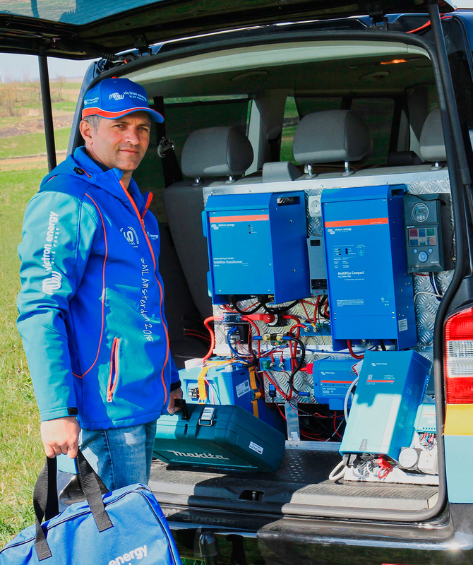 Un profesional de Victron junto a equipos de Victron en la parte trasera de un coche